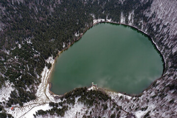 Aerial drone view of a volcanic crater lake at winter. Flying above Sfanta Ana lake, Szent Anna...