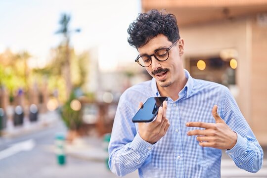 Young caucasian man talking on the smartphone with serious expression at street