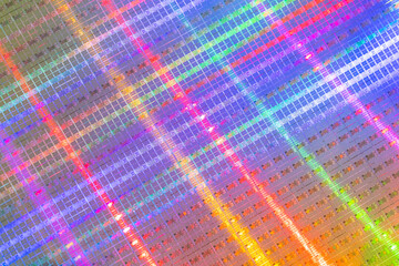 background of silicon wafer with microchips reflecting different colors used in electronics for the fabrication of integrated circuits