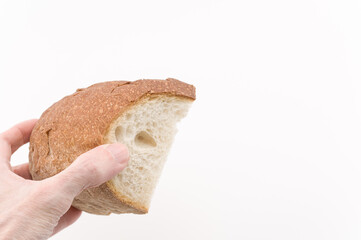 primo piano di mano che regge un pezzo di pane tagliato con sfondo bianco