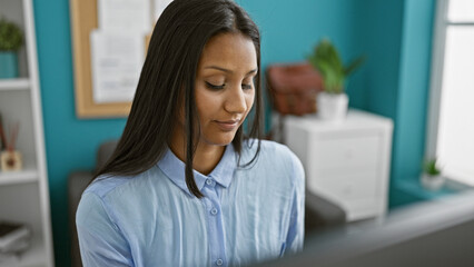 Young latin woman business worker using computer working at the office