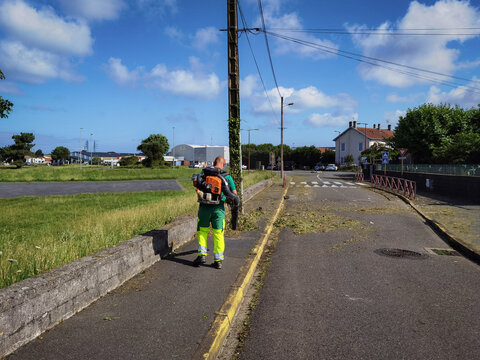 Trabalhador com o seu ventilador a soprar a rua para a limpeza da mesma