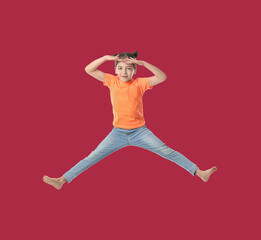 Fototapeta na wymiar Happy cute girl jumping on red background
