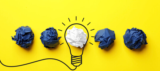 Idea. Illustration of light bulb around crumpled paper ball on yellow background, flat lay. Banner...