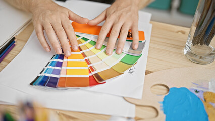 A close-up of hands selecting a color swatch from a palette, indicative of interior design planning...