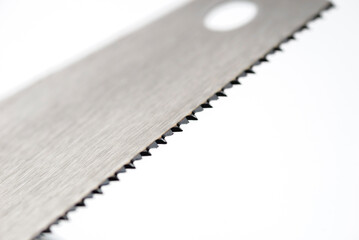 Detail of manual saw blade teeth on white background.