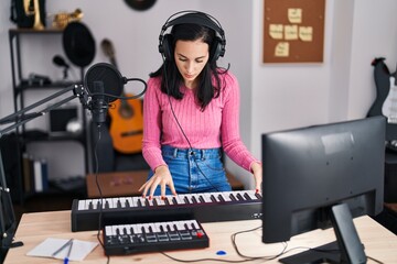 Young caucasian woman musician playing piano at music studio