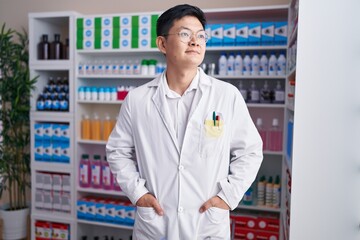 Young chinese man pharmacist smiling confident standing at pharmacy