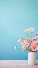 Pink cosmos flowers in vase on wooden table and blue background.
