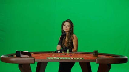 Elegant female in studio on chroma key green screen. Attractive woman in black dress at the...