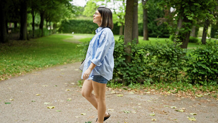Fototapeta premium Young beautiful hispanic woman walking smiling at the park in Vienna