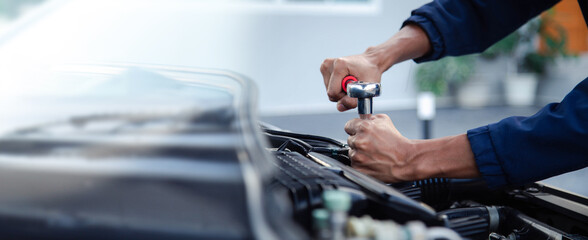 Professional mechanic working on the engine , repairing a car engine automotive workshop with a wrench, car service and maintenance,Repair service. - obrazy, fototapety, plakaty