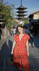 Beautiful hispanic woman smiling joyfully, confidently posing, standing on the old traditional streets of gion, kyoto, her sunny, carefree nature shining through for a fun-filled japan adventure.