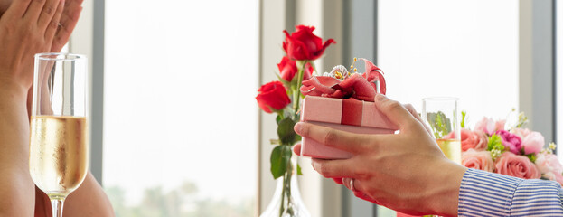 Man hand holding present box giving to girlfriend for Valentine's day, birthday or anniversary....