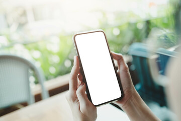 Close up of woman using cell black screen phone and sending massages on the coffee shop.