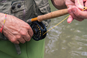Hand picking up fly fishing reel