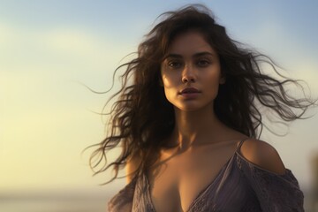 A portrait of a woman with wind-swept hair at sunset, her enigmatic beauty illuminated by the soft evening light.


