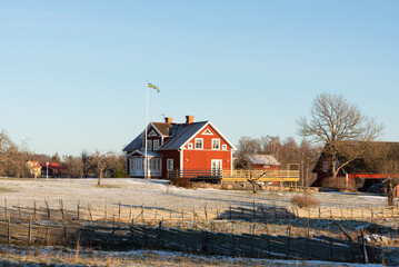 Typical red wooden house in Sweden in winter in the Bråbyggden area in eastern Småland. The photo was taken on a sunny winter day at Christmas time