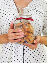 Happy woman holding jar with coockies