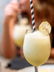 A frothy lemon cocktail garnished with a lemon slice, served in a wine glass