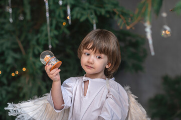 boy in white with wings in Christmas studio