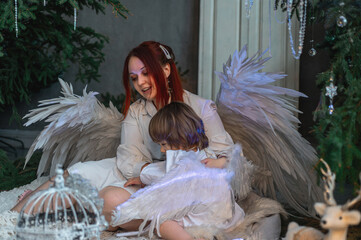 mother and son in white with wings in the Christmas studio