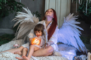 mother and son in white with wings in the Christmas studio