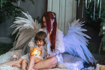mother and son in white with wings in the Christmas studio
