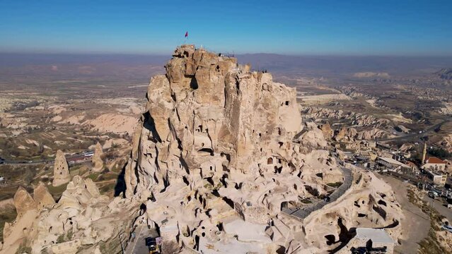 Aerial drone view of the Uchisar Castle in Cappadocia, Turkey. This tall volcanic-rock outcrop is one of Cappadocia's most prominent landmarks and visible for miles around.