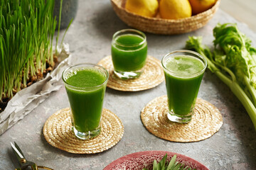 Three glasses of homemade barley grass juice with freshly grown barley grass