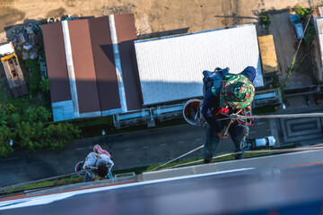 High rise cleaning worker hanging on rope access cleaning high building, work on height
