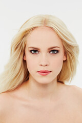 Fototapeta premium Cosmetic, makeup and portrait of woman with beauty in white background of studio. Blonde, model and serious face with facial skincare, dermatology or hair care from salon or spa mock up space
