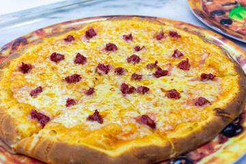 Close-up of a delicious Italian pizza with cheese and sausages (Merguez).