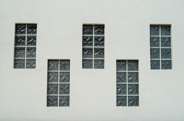Five glass brick windows on white wall closeup