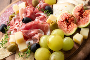 Primo piano di deliziosi salumi, formaggi e frutta fresca tipici della gastronomia italiana, cibo europeo 