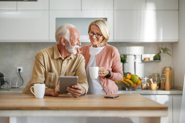 Senior couple drinking coffee in kitchen,enjoying in morning time - 706550126