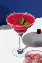 A vibrant margarita adorned with fresh mint, presented against a striking blue and white backdrop