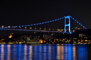 Obraz premium night view of the bosphorus bridge and boats in istanbul 