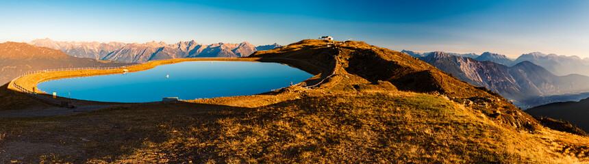 High resolution stitched alpine summer sunrise panorama with reflections in a lake at Mount Sechszeiger, Pitztal valley, Jerzens, Imst, Tyrol, Austria