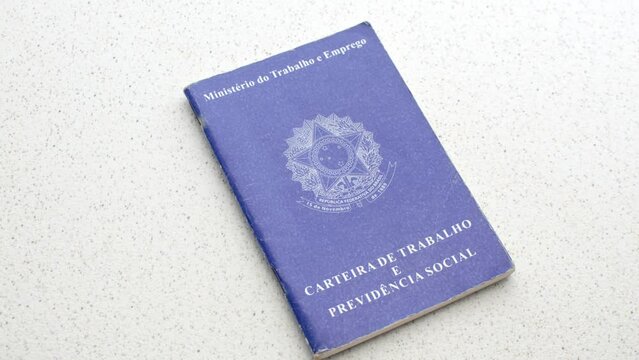Brazilian Work ID. Unemployment, job, or salary increase. On a clear surface: Employment symbols reflected on the ID, depicting the pursuit of opportunities, laid on an illuminated table.