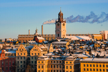 Fototapeta na wymiar Rooftop view of the old town and The German church in Stockholm, Sweden, on a cold winter day, snow and morning sunshine.