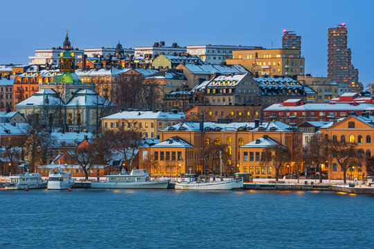 24th december 2023. Blue hour over the district of Kungsholmen, Stockholm, Sweden, with commuter boats, Kungsholm church, and Norra tornen. Clear blue sky, sunset.