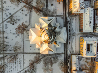 Vertical aerial view of the roof of a church in Stockholm, Sweden, with snow and the first morning sun light.