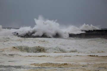 Fototapeta na wymiar Harbor entry pier and beacon during sea storm