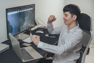 Young asian businessman using smartphones and computers. - obrazy, fototapety, plakaty