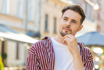 Unhappy sad handsome bearded man thinks over life concerns, suffers from unfair situation. Problem, feeling bad annoyed, burnout grief. Frustrated depressed lonely young guy standing in city street