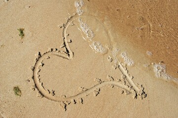A heart drawn on wet sand. Love and feelings.