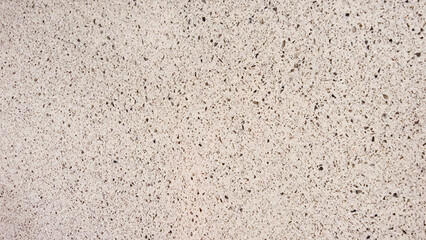 texture of grainy quartz in beige sand color, closeup view. light white marble stone texture with splashes and marble chips. terrazzo background for furnishing furniture.