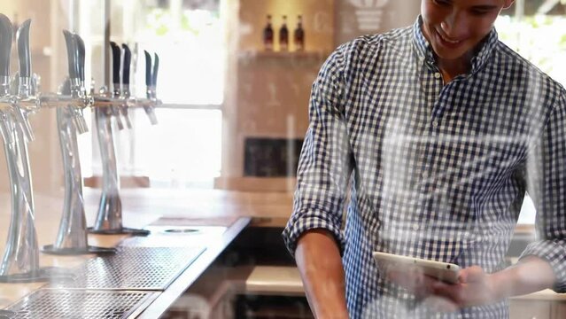 Animation of media icons and binary coding over caucasian barman using tablet