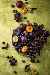 Assortment of purple fruit plum, grape, blueberry and basil